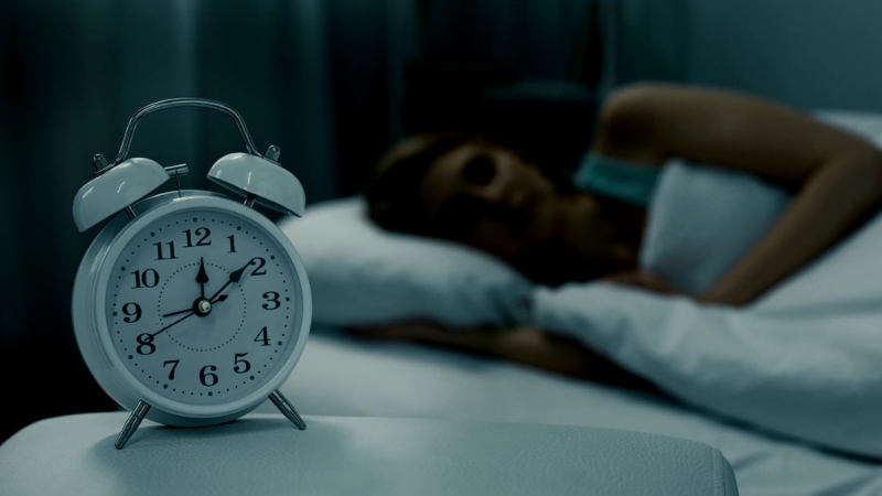 Sat pored žene koja leži u krevetu