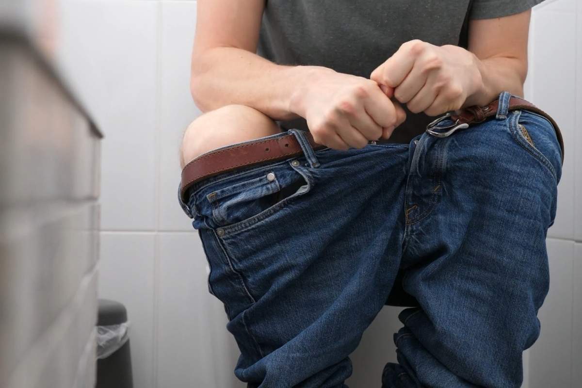 prikaz osobe koja sedi na wc šolji